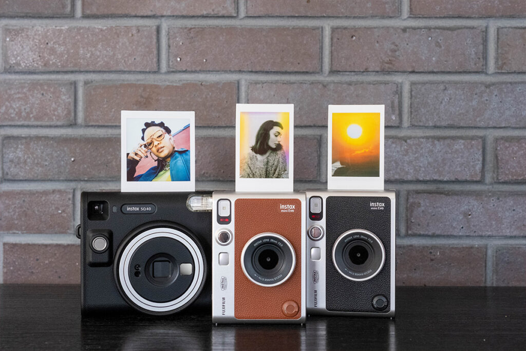 Drei Instax Kameras mit Sofortfotos