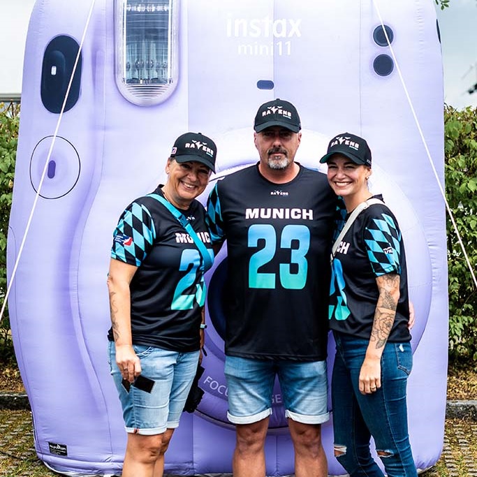 Besucher der European League of Football vor einer Instax Mini Kamera in München